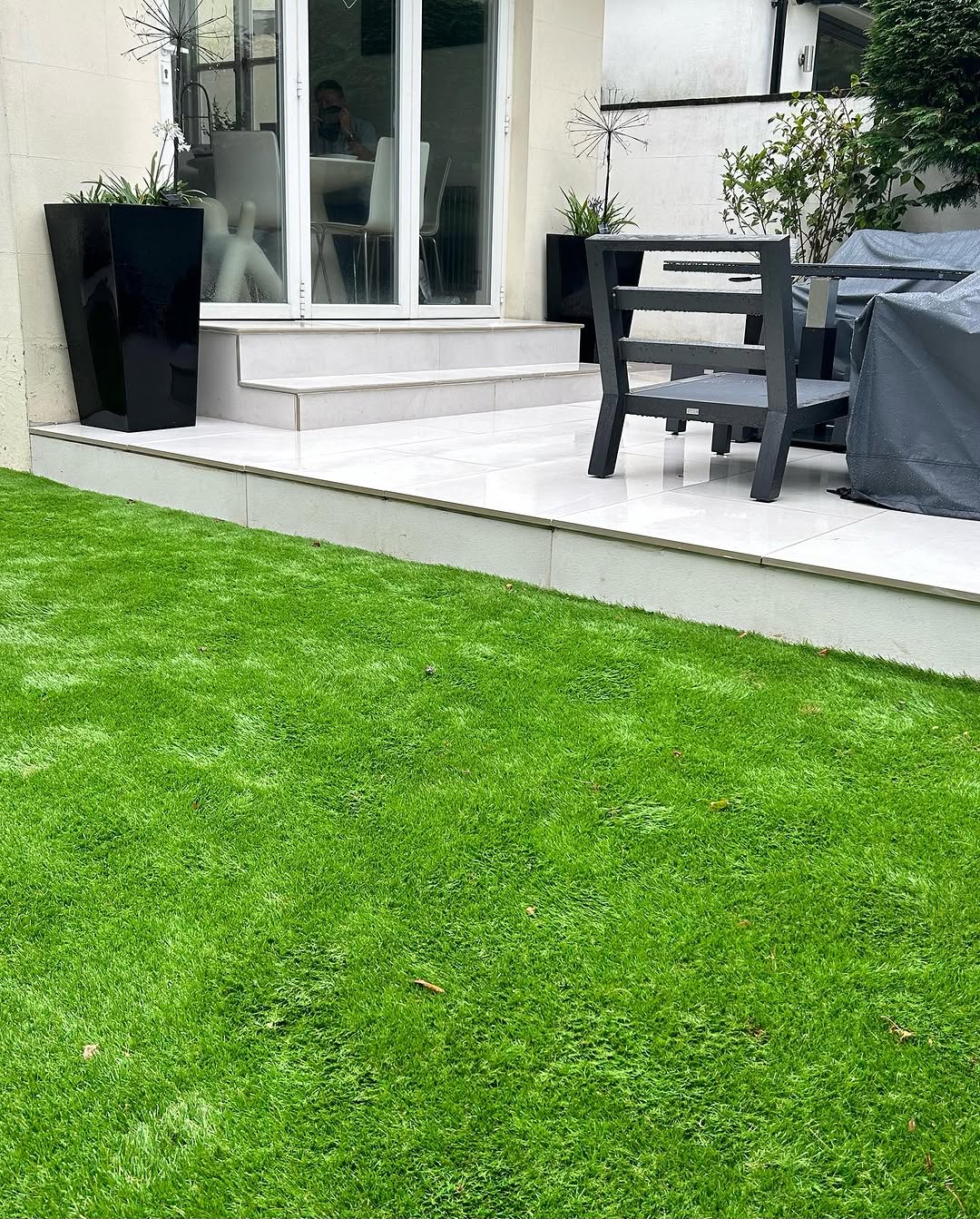 Porcelain patio with bullnose steps and artificial lawn by Jobson Landscape Contractors, Reigate